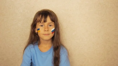 A child with painted flags of Russia and Ukraine. Stock Footage