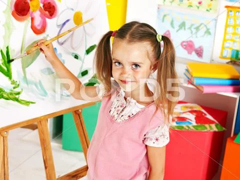 Child painting at easel. Stock Photos