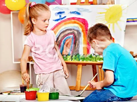 Child painting at easel. Stock Photos