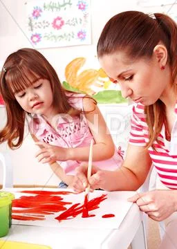 Child painting at easel. Stock Photos
