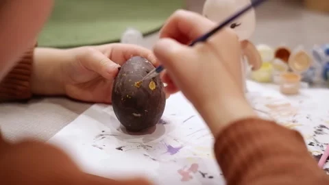 Child painting easter egg gold dots Stock Footage 303351724
