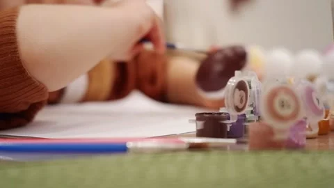Child painting easter eggs with brown paint Stock Footage 303351066