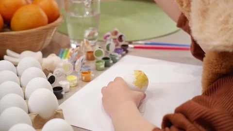 Child painting easter eggs at home Stock Footage 303341817