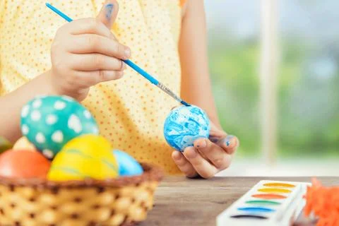 Child is painting egg for Easter Stock Photos