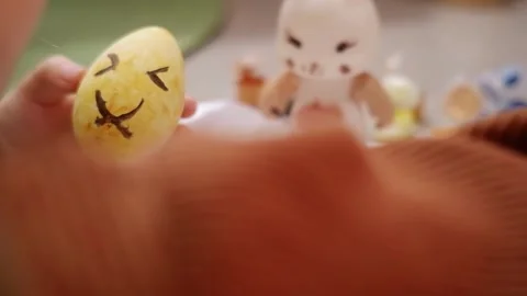 Child painting smiling face on easter egg Stock Footage 303351632