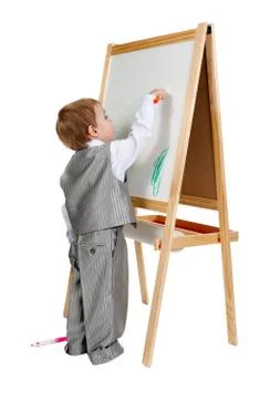 A child paints on an easel in the studio Stock Photos