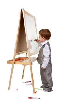 A child paints on an easel in the studio Stock Photos
