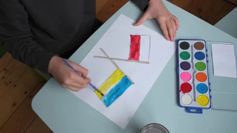 A child paints the flags of Poland and Ukraine Stock Footage 180674657