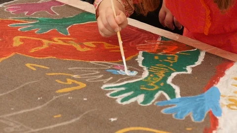 A child paints a hand with a thin brush Stock Footage 112003603