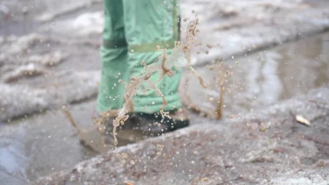 A child in the Park jumping on puddles. Splashes of water run up on the parties 库存影片 88471379