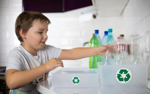 A child participates in sorting plastic in the kitchen to be sent for recycling Stock Photos