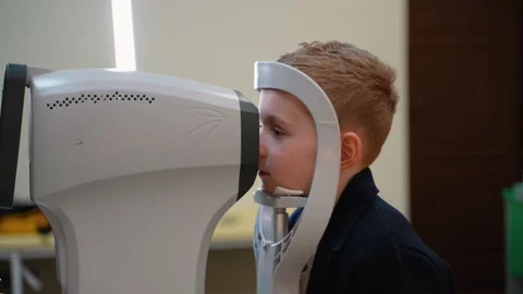 Child patient undergoing vision screening with modern medical equipment Stock Footage 310806456
