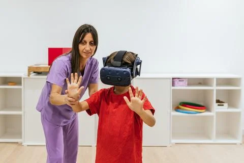 Child patient using vr technology in vision therapy session with optometrist Stock Photos