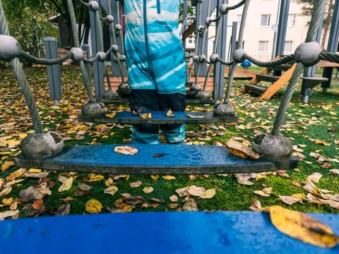 Child Pausing Between Suspended Steps on Playground Bridge Stock Photos