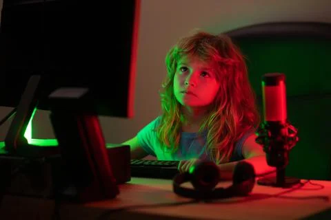Child with pc computer at night. Overuse and addiction kids from gadgets. Stock Photos