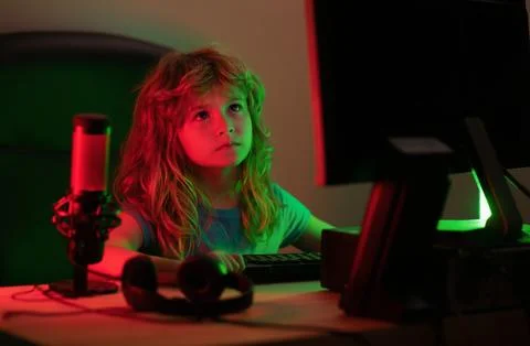 Child with pc computer at night. Overuse and addiction kids from gadgets. Stock Photos