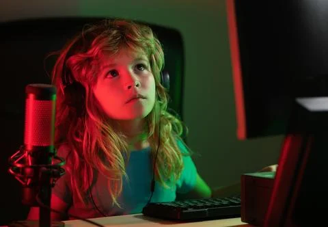 Child with pc computer at night. Overuse and addiction kids from gadgets. School Stock Photos