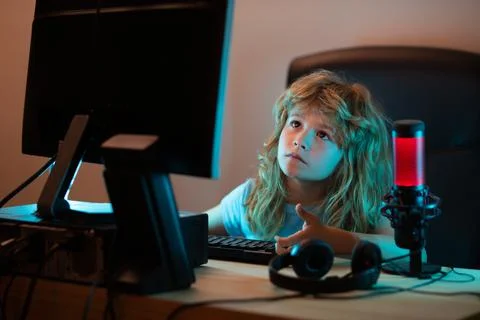 Child with pc computer at night. A pretty child learns a lesson using a desktop Stock Photos
