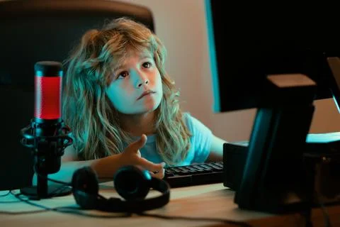 Child with pc computer at night. A pretty child learns a lesson using a desktop Stock Photos