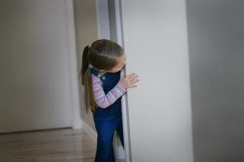 Child Peeks Around A Corner Stock Photos