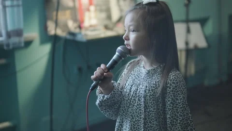 Child performer singing at a music class or rehearsal in a creative studio. Stock Footage 335602272