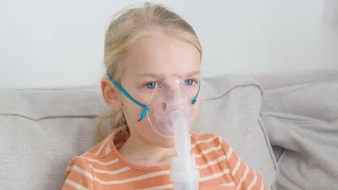 Child performing inhalation therapy with a nebulizer at home Stock Footage 302767094