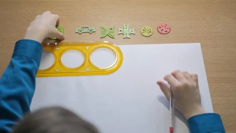 Child performs a drawing using a graphic ruler, pen and template. Stock Footage 129402823