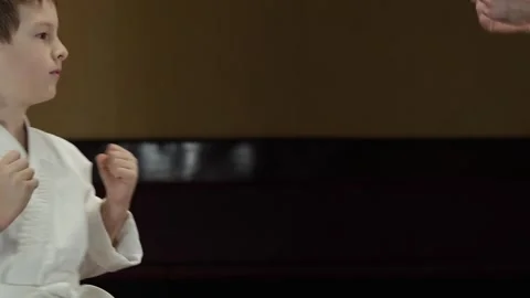 A child performs an exercise raising legs to arms together with a trainer Stock Footage 301507523