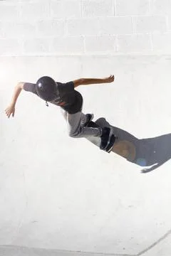 Child performs exercises and tricks in a flowing skate bowl Stock Photos
