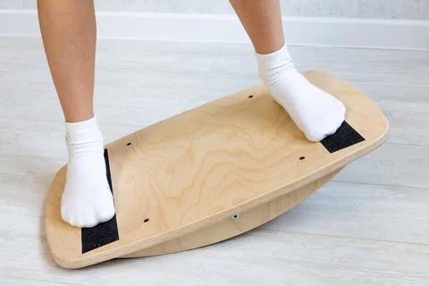 The child performs exercises on the balancer from the valgus of the foot. The Stock Photos