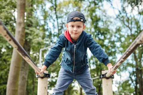The child performs exercises on parallel bars on the street. Active lifestyle Stock Photos
