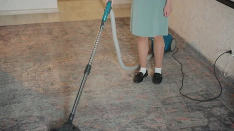 Child performs household cleaning task. Young girl vacuuming carpet indoors Stock Footage 336864301