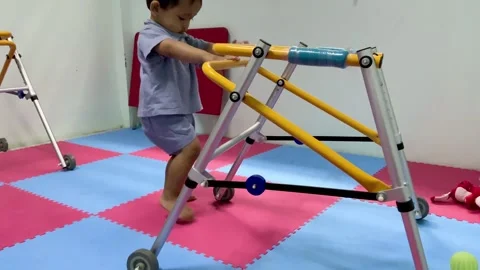 Child with a physical disability using a mobility walker for physical therapy 스톡 동영상 341498312