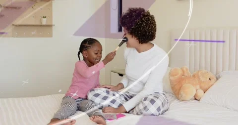 Child picking up brush, applying blush to woman on bed, purple overlays showing Stock Footage 323355220