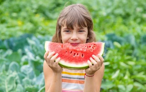 A child on a picnic eats a watermelon. Selective focus. Stock Photos