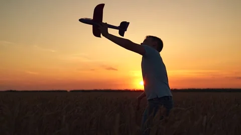Child pilot dreams of flying, traveling. Happy boy runs with toy airplane across Stock Footage 301874853