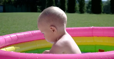 Child Play and Having Fun in Inflatable Pool on Green Lawn in a Sunny Day 스톡 동영상 65781587