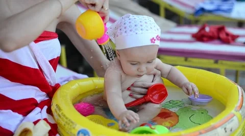 Child play and having fun in inflatable rubber pool on a sunny day Stock Footage 67328489