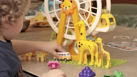 Child play with a plastic constructor at home on table. Children and educational Stock Photos
