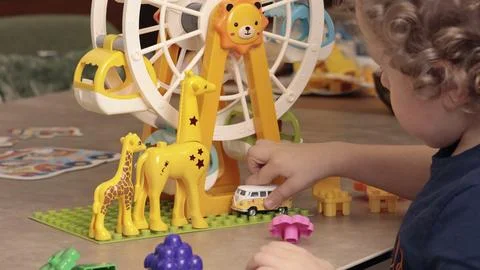 Child play with a plastic constructor at home on table. Children and educational Stock Photos
