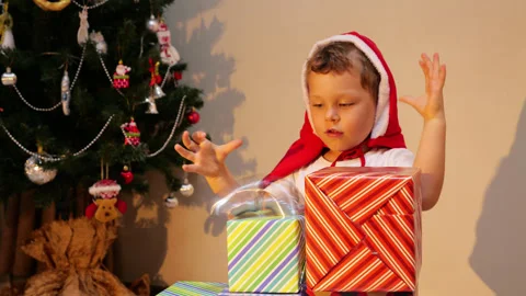 Child play with spring, launch it from staircase made from christmas presents Stock Footage 300370601
