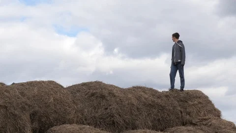 Child play with a stack of straw against the sky Video stock 128326865