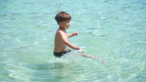 Child playing and jumping in the turquoise waters of the Mediterranean sea Stock Footage 286722293