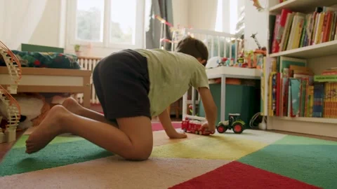 Child playing and rolling a fire engine in his bedroom, in France Stock Footage 287189840