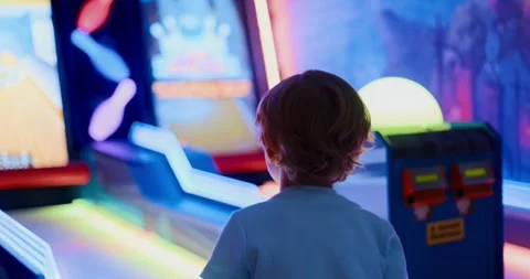 Child Playing Arcade Bowling Game in Vibrant Gaming Center Vídeos de archivo 313421226