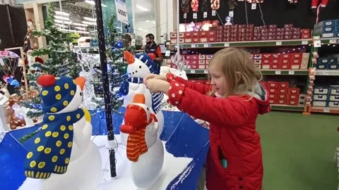 Child playing with artificial snow in store. Christmas decorations in the shop Video stock 146123434