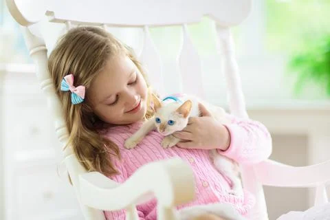 Child playing with baby cat. Kid and kitten. Stock Photos
