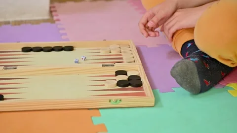 Child playing backgammon on colorful play mat at home Stock Footage 290052891
