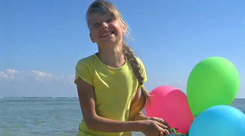 Child playing with balloons at the beach. Stock Footage 24000552