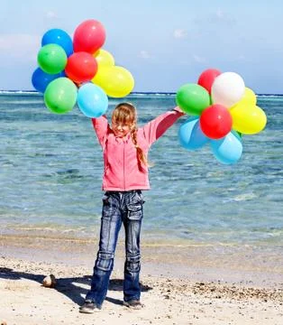 Child playing with balloons at the beach Foto stock